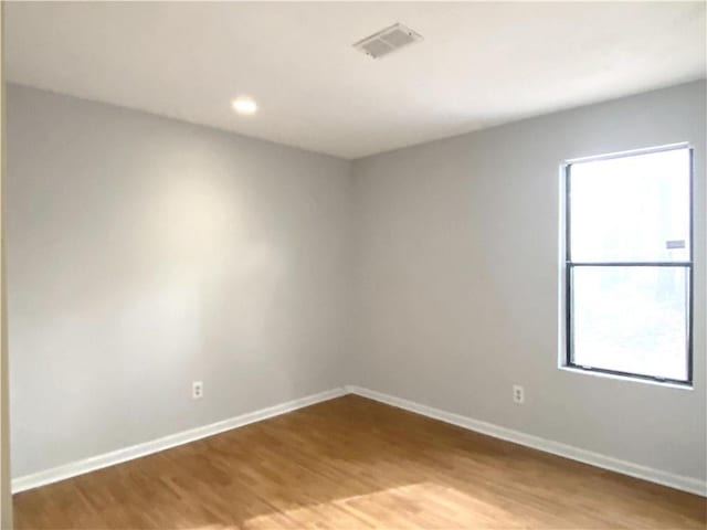 unfurnished room with a healthy amount of sunlight and wood-type flooring