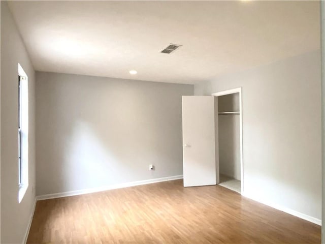 unfurnished bedroom featuring hardwood / wood-style flooring and a closet