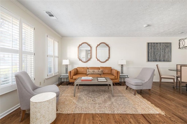 living room featuring crown molding, dark hardwood / wood-style floors, and a textured ceiling