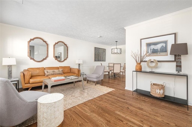 living room with a textured ceiling, ornamental molding, and hardwood / wood-style floors