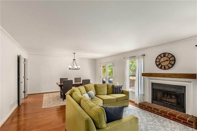 1341 Sheffield Glen Way NE, Atlanta, GA 30329 - living area featuring wood finished floors, a brick fireplace, a chandelier, baseboards, and ornamental molding