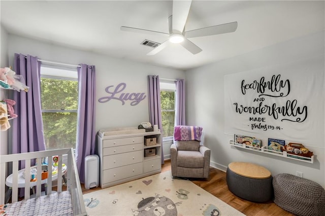 1341 Sheffield Glen Way NE, Atlanta, GA 30329 - bedroom with a crib, multiple windows, a ceiling fan, and wood finished floors