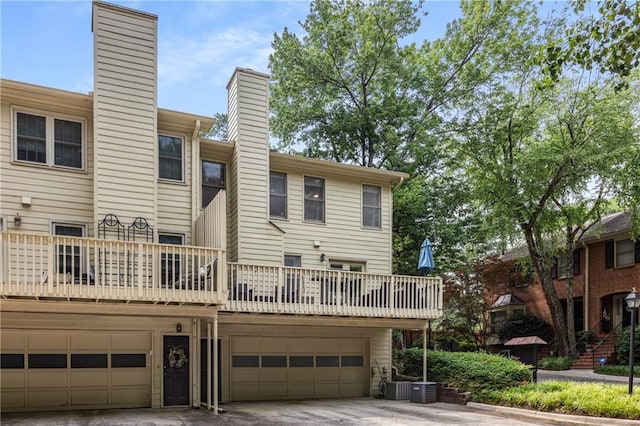1341 Sheffield Glen Way NE, Atlanta, GA 30329 - back of property featuring a chimney, a garage, central AC, and concrete driveway