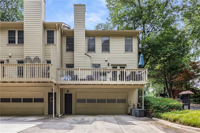 1341 Sheffield Glen Way NE, Atlanta, GA 30329 - rear view of property with a chimney, an attached garage, driveway, a balcony, and central AC
