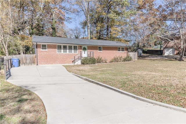 single story home featuring concrete driveway, a front lawn, fence, and brick siding