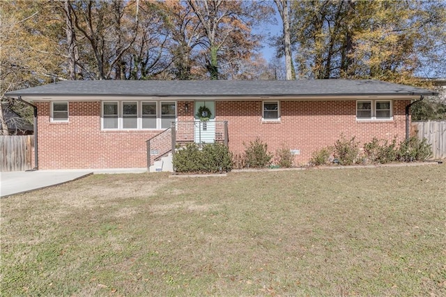 ranch-style home with brick siding, a front yard, and fence