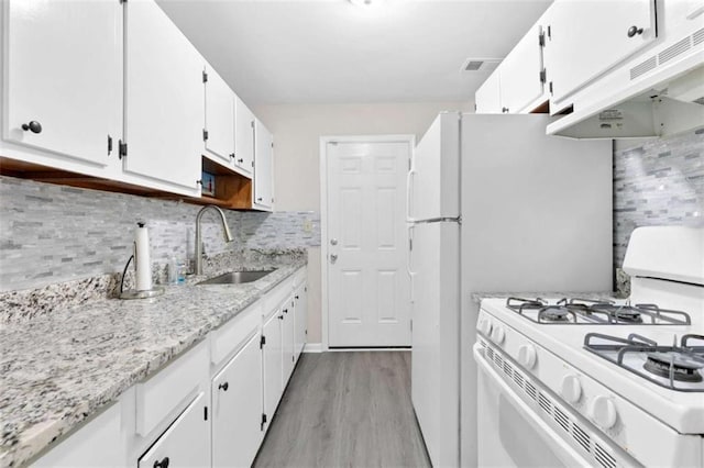 6671 Gano Dr, Riverdale, GA 30274 - kitchen with white range with gas cooktop, extractor fan, light wood finished floors, white cabinetry, and tasteful backsplash