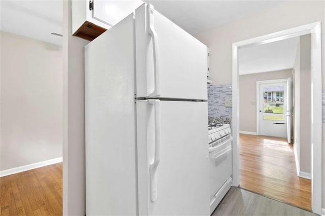 6671 Gano Dr, Riverdale, GA 30274 - kitchen with white appliances, light wood-style floors, white cabinets, and decorative backsplash