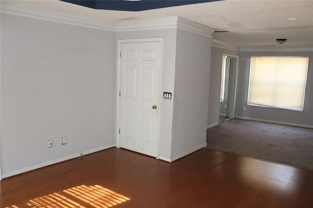 empty room featuring crown molding and dark hardwood / wood-style flooring