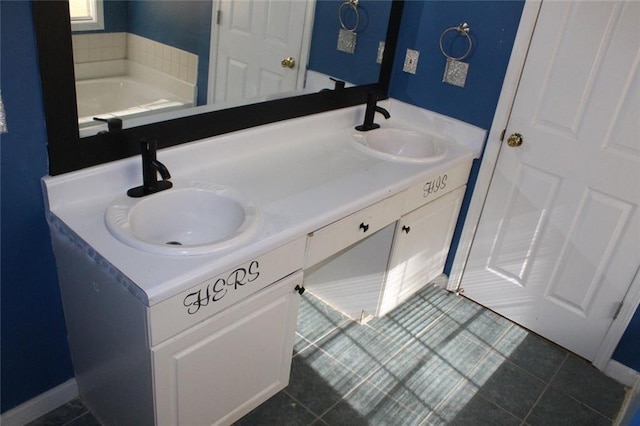 bathroom with a tub to relax in, tile patterned floors, and vanity