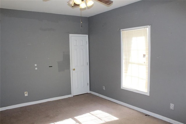 carpeted spare room with ceiling fan