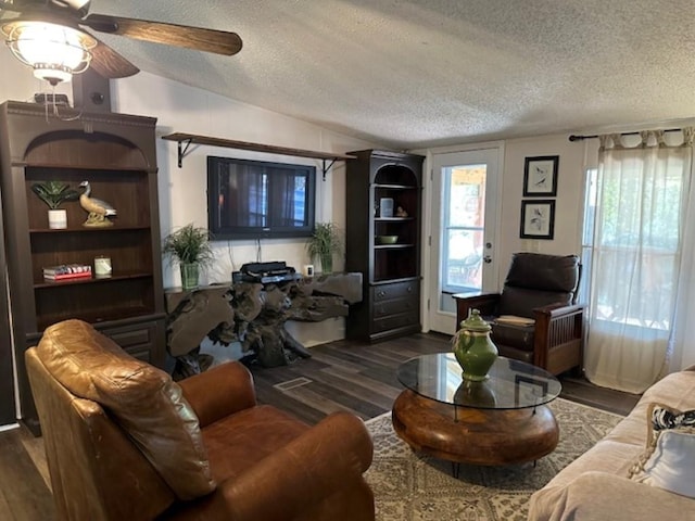 living room featuring ceiling fan, lofted ceiling, a textured ceiling, and wood finished floors