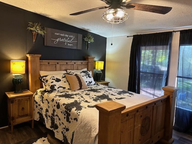 bedroom featuring a ceiling fan, dark wood-style flooring, and a textured ceiling