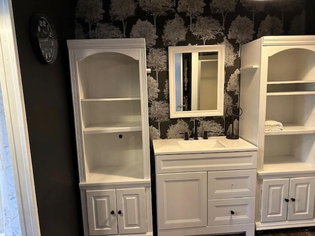 bathroom featuring vanity and wallpapered walls