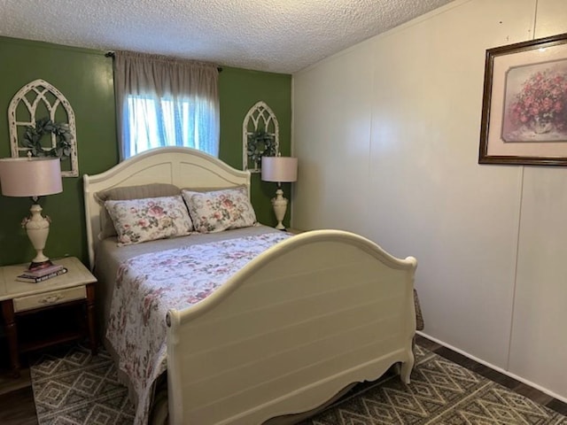 bedroom with wood finished floors and a textured ceiling