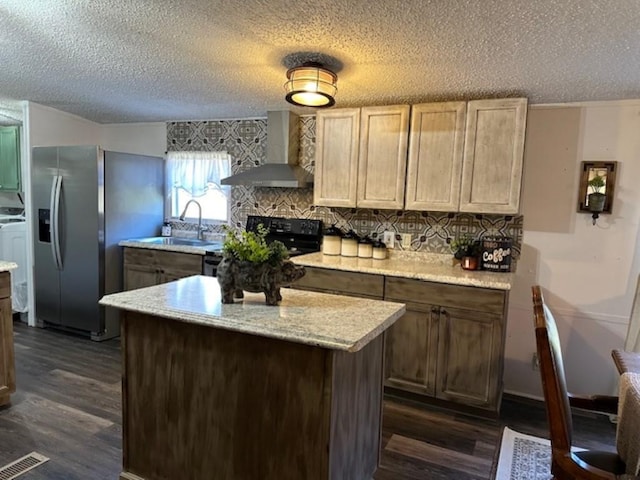 kitchen with visible vents, dark wood-style flooring, a sink, stainless steel refrigerator with ice dispenser, and wall chimney range hood