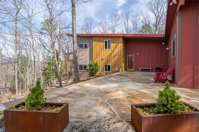 rear view of property with a vegetable garden and a patio