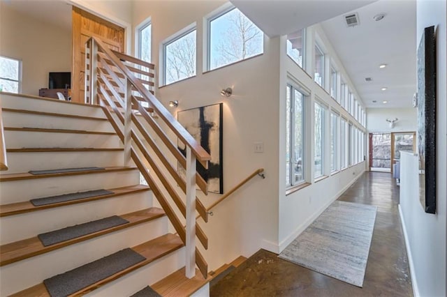 stairs featuring visible vents, baseboards, and recessed lighting