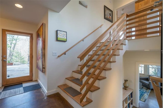 entryway with recessed lighting, stairs, baseboards, and concrete floors