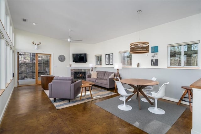 living room with a fireplace, finished concrete floors, baseboards, and visible vents