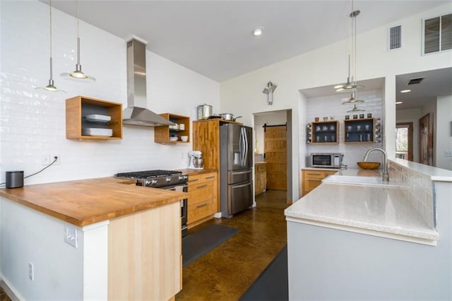 kitchen featuring a sink, open shelves, visible vents, wall chimney range hood, and appliances with stainless steel finishes