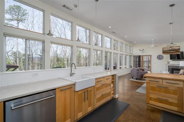 kitchen featuring plenty of natural light, a sink, visible vents, and stainless steel dishwasher