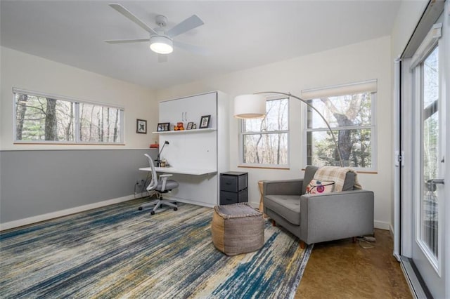 carpeted office space with baseboards and a ceiling fan