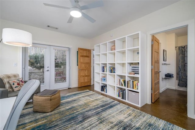 living area with a ceiling fan, french doors, baseboards, visible vents, and wood finished floors