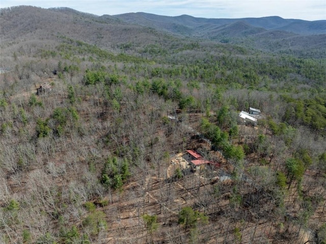 drone / aerial view with a wooded view and a mountain view