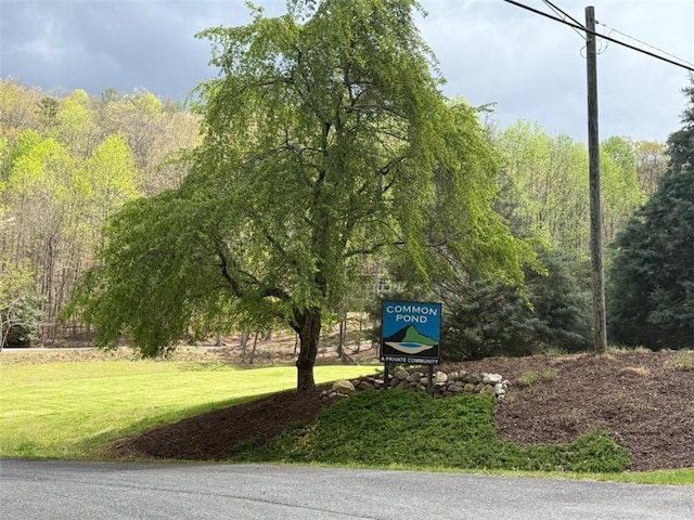 surrounding community featuring a wooded view and a lawn
