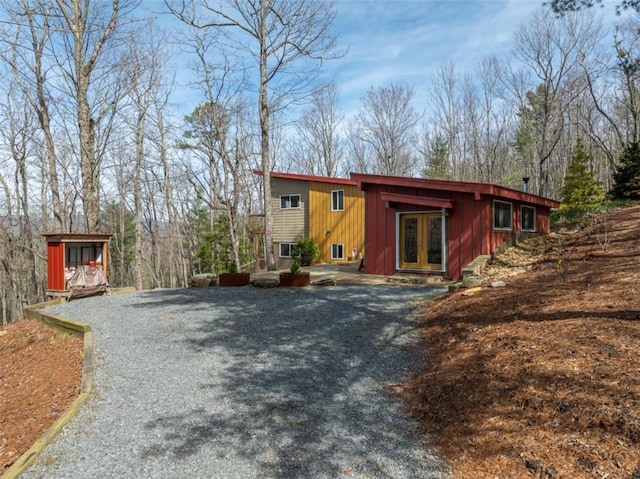 view of front facade featuring driveway, french doors, and board and batten siding