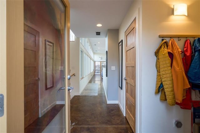hallway featuring visible vents, finished concrete flooring, baseboards, and recessed lighting