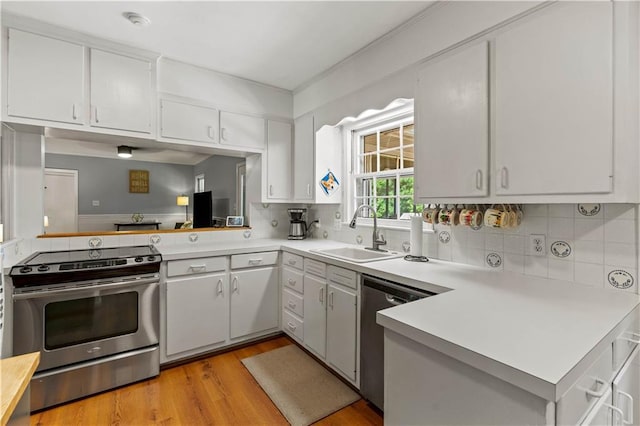650 Crestview Ter, Gainesville, GA 30501 - kitchen featuring stainless steel appliances, light countertops, light wood-style flooring, tasteful backsplash, and a peninsula