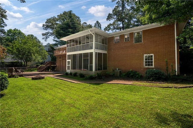 650 Crestview Ter, Gainesville, GA 30501 - rear view of house featuring a sunroom, a lawn, brick siding, and a fire pit