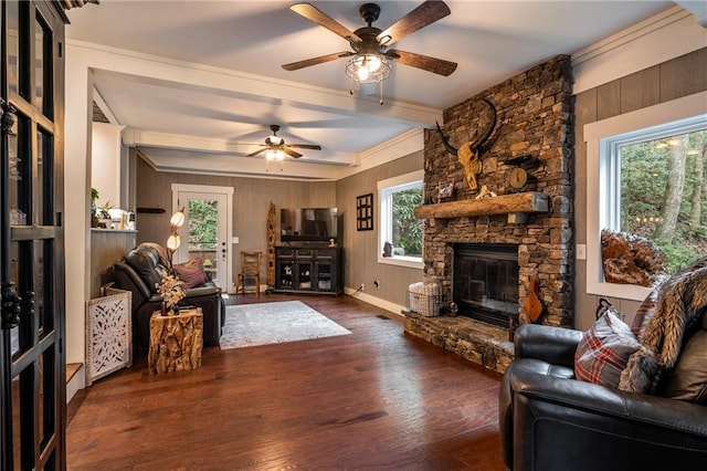 living room with wood walls, a fireplace, wood finished floors, and a ceiling fan