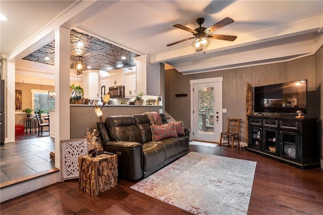 living area featuring ceiling fan, wooden walls, and dark wood-type flooring