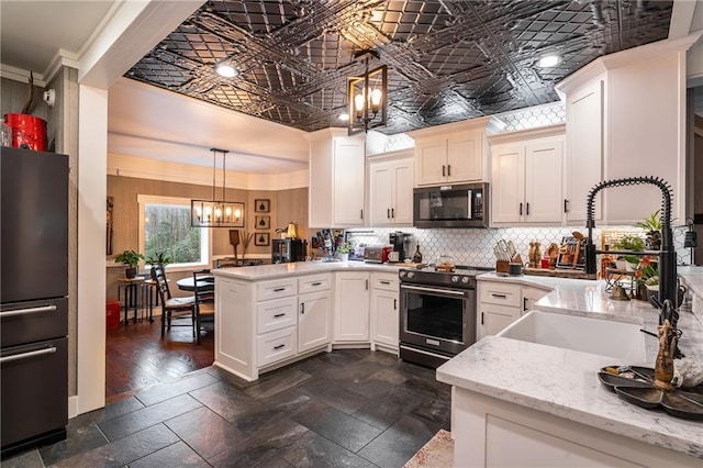 kitchen with an ornate ceiling, freestanding refrigerator, black microwave, and stainless steel stove