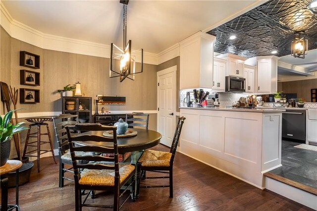 dining area with dark wood-type flooring, a chandelier, and crown molding