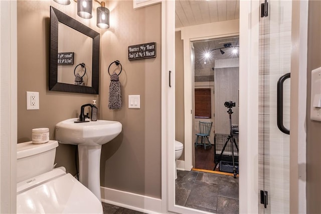 bathroom with toilet and baseboards