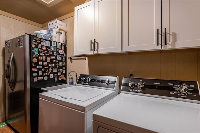 laundry area featuring washing machine and dryer, cabinet space, and a sink