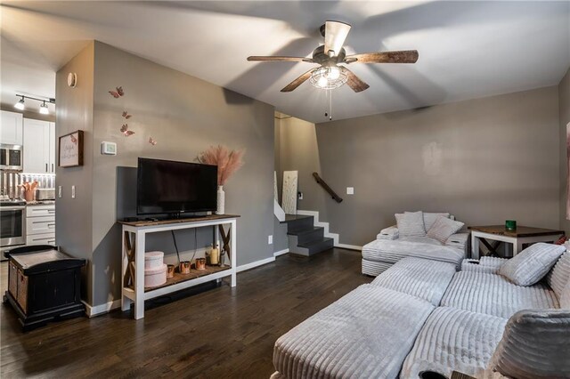 living room featuring ceiling fan, stairway, wood finished floors, and baseboards