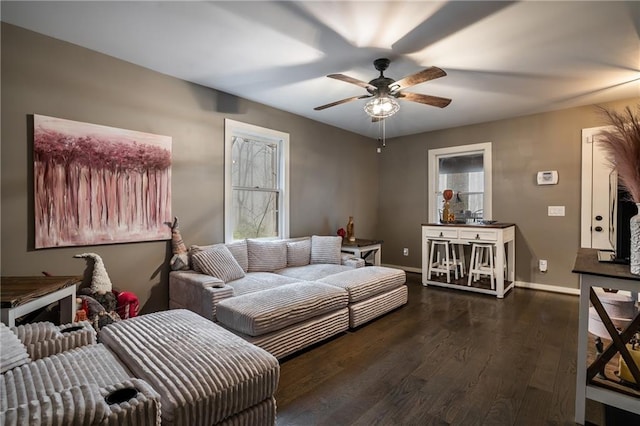 living area with plenty of natural light, dark wood-style floors, ceiling fan, and baseboards