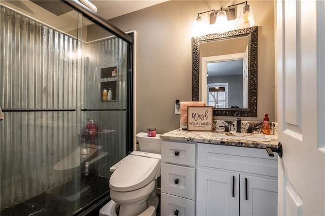 full bath with a stall shower, vanity, and toilet