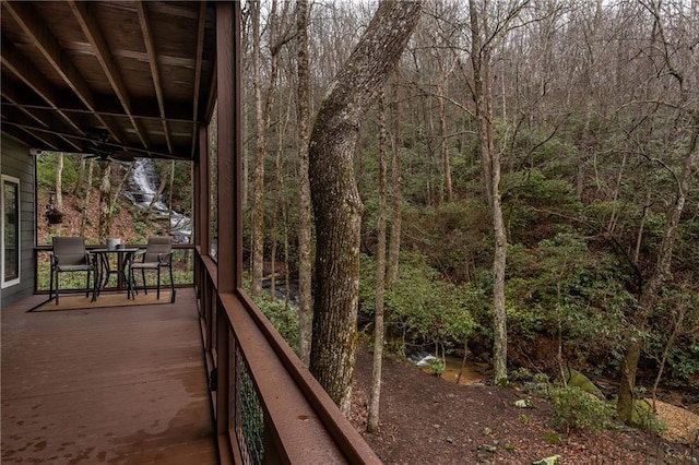 deck featuring a forest view and ceiling fan