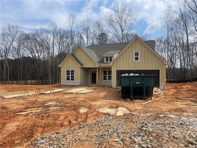 view of front of home with a garage, driveway, and a shingled roof