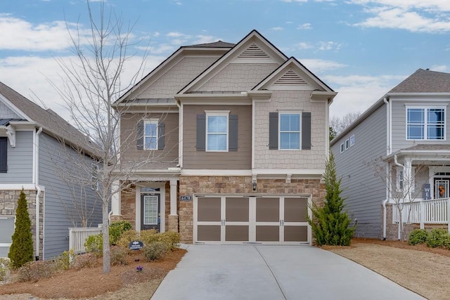 craftsman-style home featuring stone siding, concrete driveway, and an attached garage