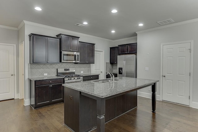 kitchen featuring appliances with stainless steel finishes, visible vents, a sink, and light stone counters