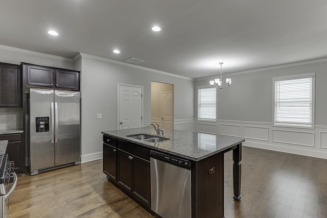 kitchen featuring dark wood-style floors, visible vents, appliances with stainless steel finishes, a sink, and dark stone countertops