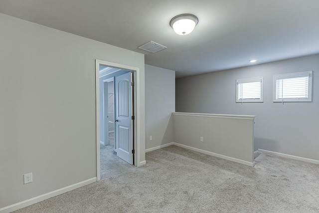 empty room featuring carpet, visible vents, and baseboards