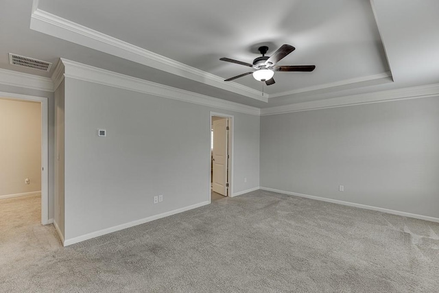 empty room featuring a tray ceiling, visible vents, and carpet flooring